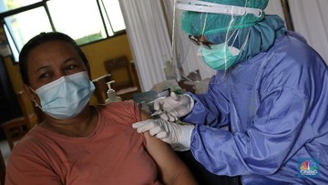 Tenaga kesehatan menyuntikan vaksin kepada warga di MTs As-Syafiiyah, Cilangkap, Jakarta, Kamis (3/6/2021). Vaksinasi massal di zona merah RT 03/ RW 03 Cilangkap akibat klaster halal bi halal itu dilakukan terhadap warga yang telah menjalani tes usap dengan hasil negatif. Vaksinasi diberikan kepada warga yang sebelumnya telah dinyatakan negatif Covid-19 hasil swab PCR. (CNBC Indonesia/Andrean Kristianto)