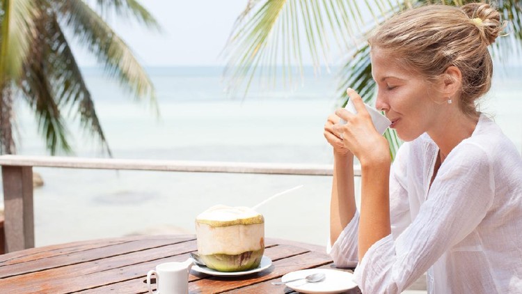 air kelapa Young woman enjoys drinking coffee and coconut. Koh Phangan island, Thailand