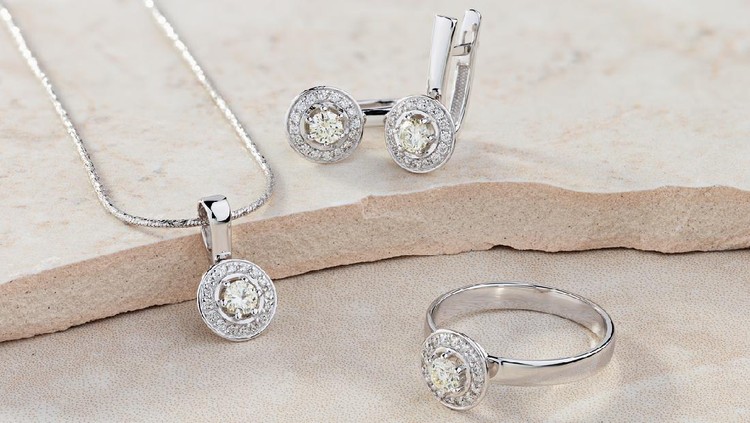 Elegant jewelry set of white gold ring, necklace and earrings with diamonds. Silver jewellery set with gemstones. Product still life concept