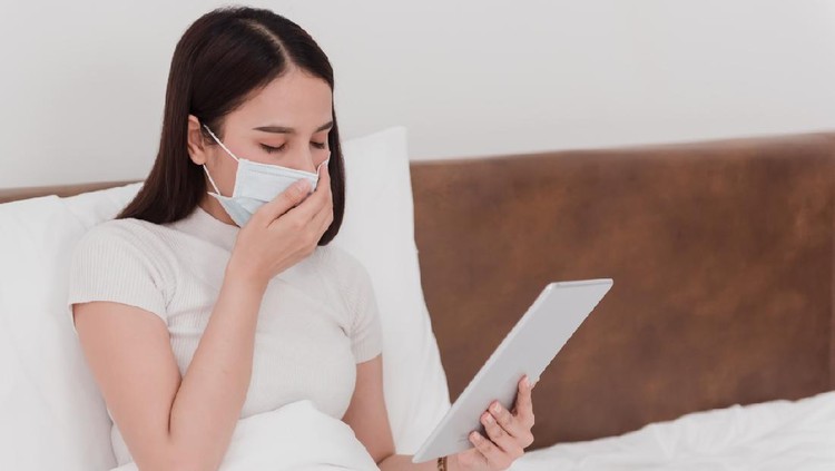 Asian women wearing masks, sick doctors, coughing, grasping the nose and face. Holding the tablet in the hand in the bedroom