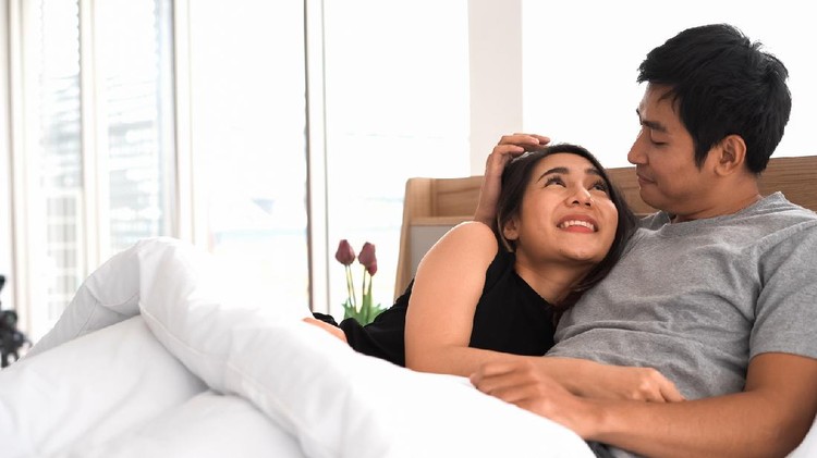 Ilustrasi Seks Happy cute couple in love lying on the bed.