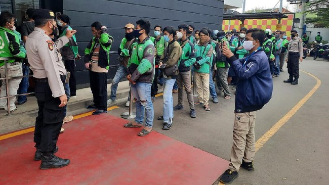 Camat Serang dan personel kepolisian menertibkan kerumunan antrean imbas pemesanan BTS Meal pakai ojol di McD.