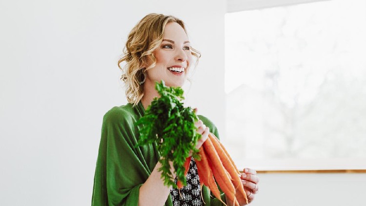Young woman with fresh carrots