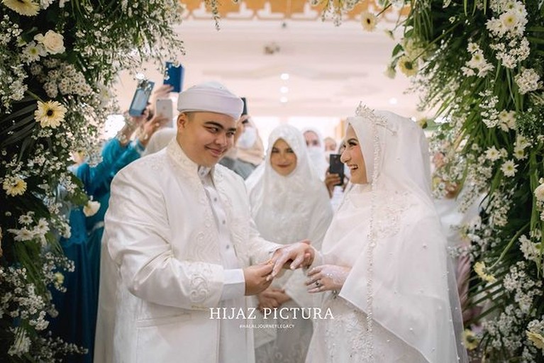 Putra bungsu Alm Ustaz Arifin Ilham, Ameer Azzikra telah resmi menikahi Nadzira Shafa. Yuk kita intip momen bahagia mereka!