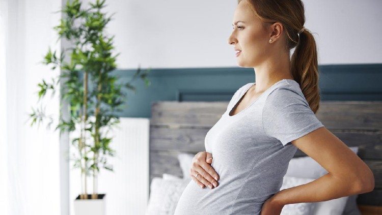 Healthcare, treatment. Young pregnant woman feeling sudden pain in her back. Future mom suffering from backpain. High quality photo