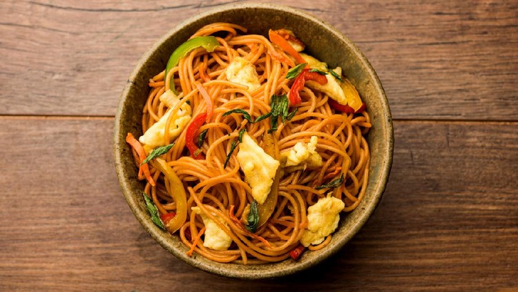 Egg Schezwan/hakka noodles, popular indochinese food served in a bowl with chopsticks. selective focus