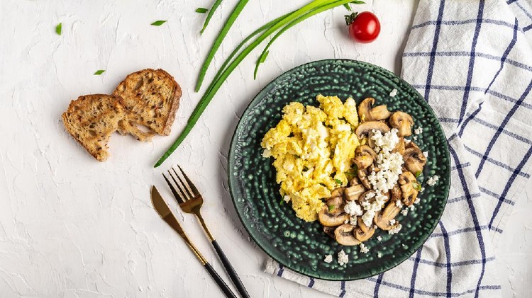 Scrambled Eggs with Mushrooms and Cottage Cheese. Delicious breakfast or snack on a light background, top view.