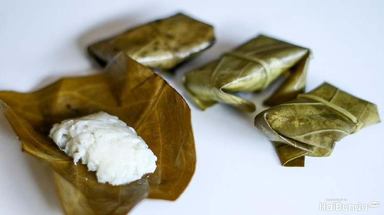tape ketan khas kuningan, jawa barat Fermented sticky (tape ketan) wrapped in guava leaves on white background.