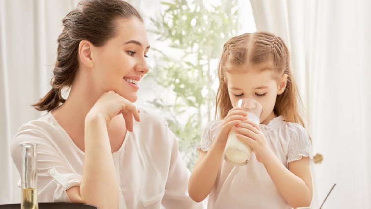 girl drinking milk at the kitchen