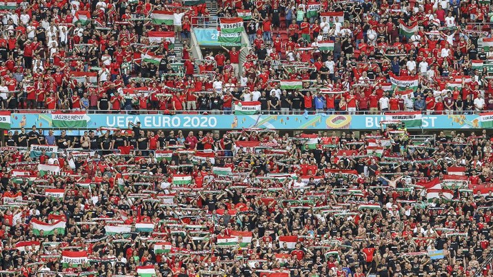 Suporter Hongaria menghadiri pertandingan grup F kejuaraan sepak bola Euro 2020 antara Hongaria dan Portugal di stadion Ferenc Puskas di Budapest, Hongaria, Selasa, (15/6/2021). (AP/Bernadett Szabo)