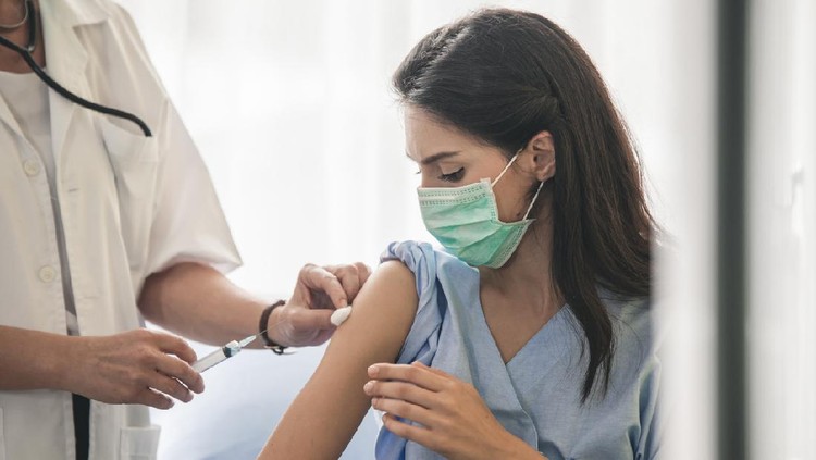 Doctor giving patient vaccine, flu or influenza shot or taking blood test with needle. Nurse with injection or syringe. Cropped image of handsome mature doctor in protective gloves making woman an injection