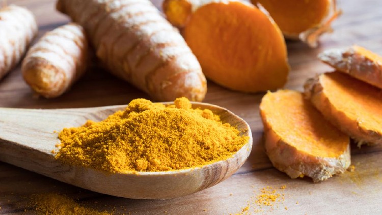temulawak Turmeric powder with fresh turmeric root in the background