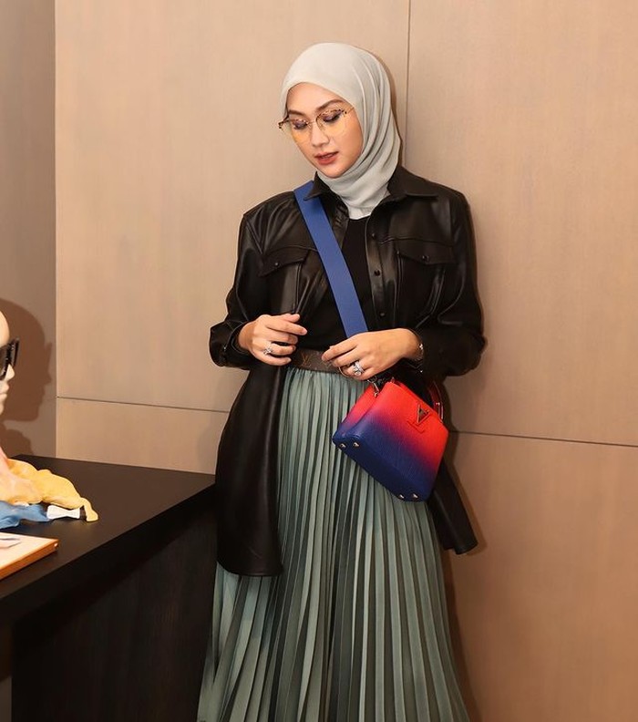 Untuk tampilan dengan kesan yang bold, kamu bisa gunakan leather shirt sebagai outer dan padukan dengan rok plisket polos. (foto:instagram.com/indahnadapuspita)