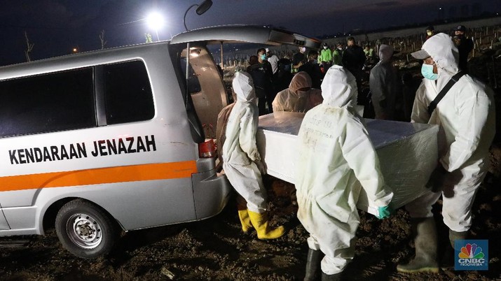 Sejumlah petugas pemakaman lengkap dengan menggunakan alat pelindung diri (APD) memakamkan jenazah Covid-19 di Tempat Pemakaman Umum (TPU) Rorotan, Kota, Jakarta Utara, Jumat (25/6/2021). (CNBC Indonesia/Andrean Kristianto)