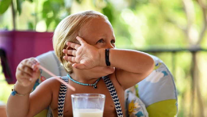 The little boy does not want to drink more milk.