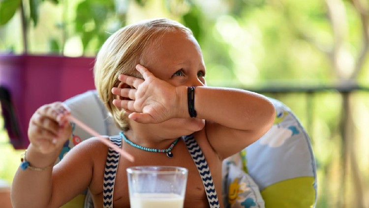 The little boy does not want to drink more milk.