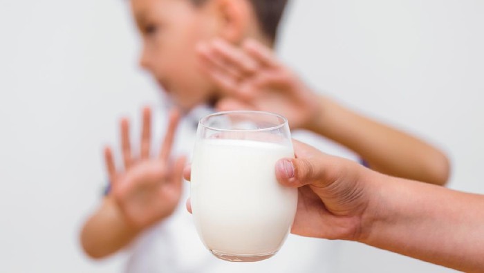 The little boy does not want to drink more milk.