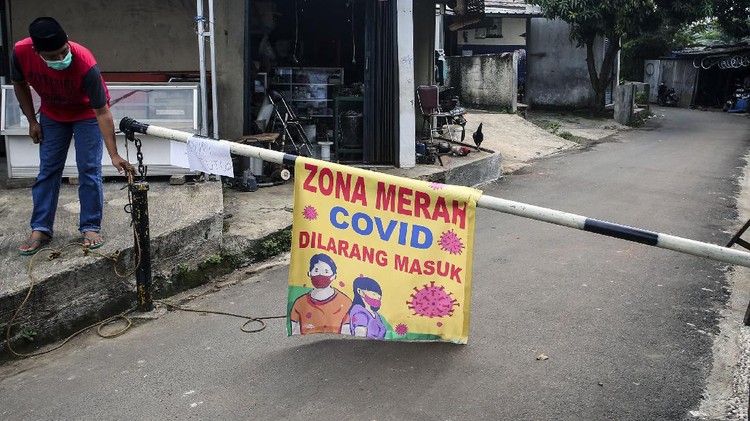 Warga menjaga pintu masuk ke pemukiman yang ditutup karena menjadi daerah zona merah penyebaran COVID-19 di Pamulang Barat, Tangerang Selatan, Banten, Rabu (23/6/2021). Lockdown lokal dilakukan karena sebanyak 17 warga di daerah itu terpapar COVID-19. ANTARA FOTO/Muhammad Iqbal/hp.