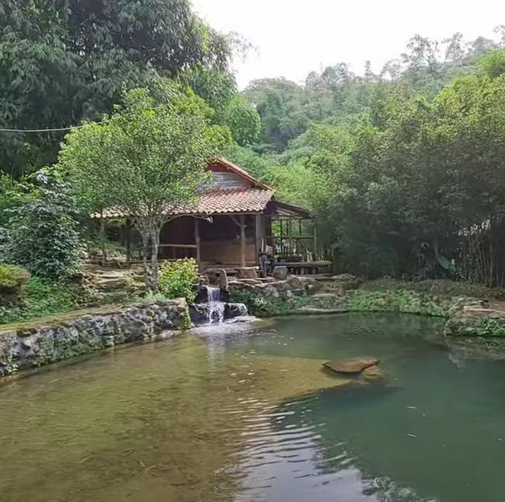 <p>Rumahnya merupakan rumah panggung dari bambu. Kemudian di depannya terdapat kolam air yang jernih tanpa ikan. (Foto: YouTube Alman Mulyana)</p>