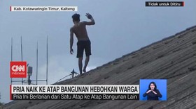 VIDEO: Pria Naik Ke Atap Bangunan Hebohkan Warga