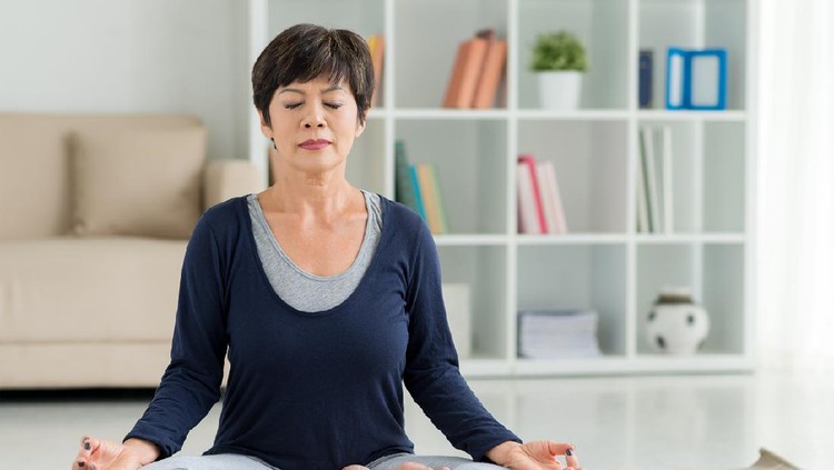 Mature woman sitting on the floor in lotus position