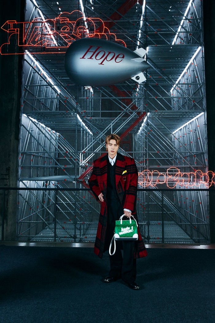 Dengan nuansa hitam merah, Jin tampak sangat elegan memegang tas berwarna hijau. /Photos: Courtesy of Louis Vuitton/Instagram @voguejapan