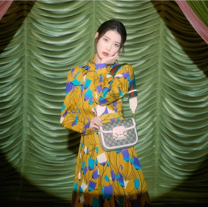 Tampak harmonis dengan latar belakang nuansa hijau, IU kali ini menggunakan Gucci Horsebit 1955 Mini Bag bergaya vintage, yang dibanderol dengan harga 2450 USD./ Foto: instagram.com/Gucci
