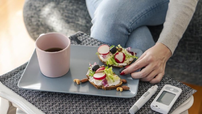 Young diabetic woman having breakfast at home.