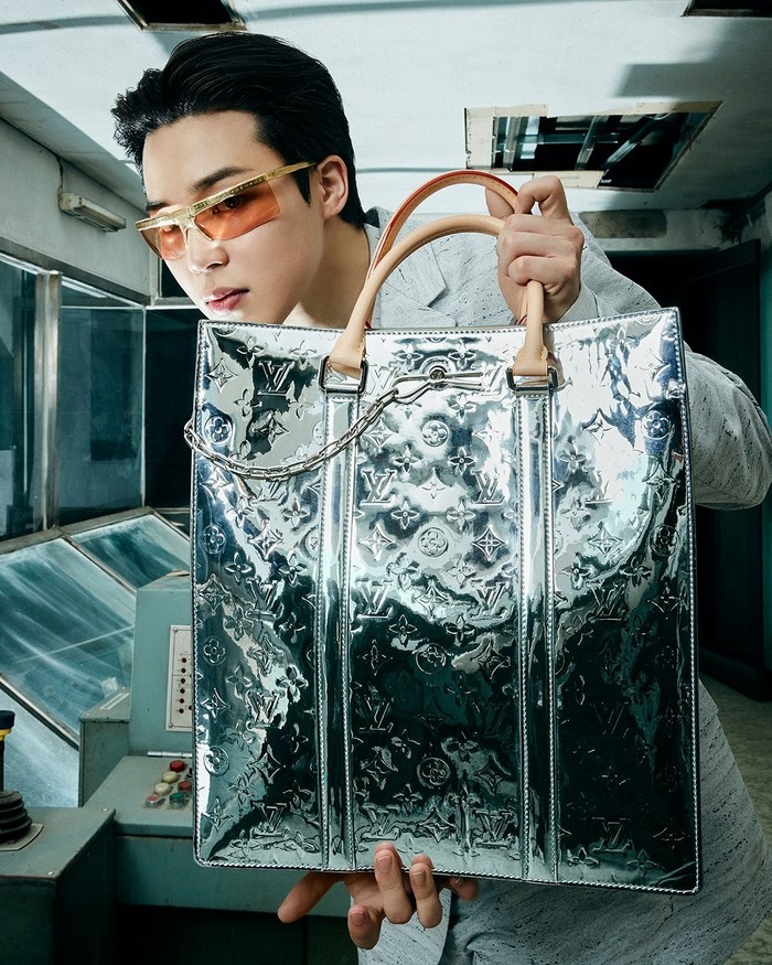 Jimin tampil nyentrik dalam balutan setelan berwarna abu-abu dan kacamata berbingkai emas. Ia memperlihatkan tote bag silver dengan detail logo Louis Vuitton. (Foto: Instagram.com/louisvuitton)