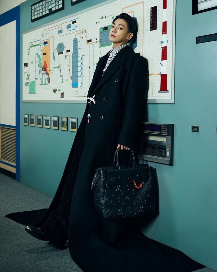 Jungkook tampil serba hitam dengan setelan jas dan tas jinjing yang diperlihatkannya. Jas yang ia pakai cukup unik karena panjangnya hingga ‘menyapu’ lantai. (Foto: Instagram.com/louisvuitton)