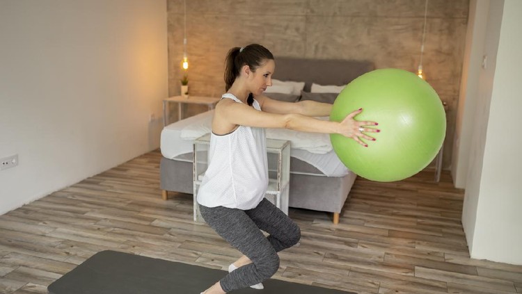 Pregnant woman exercising at home during the third trimester practicing healthy and active lifestyle during pregnancy