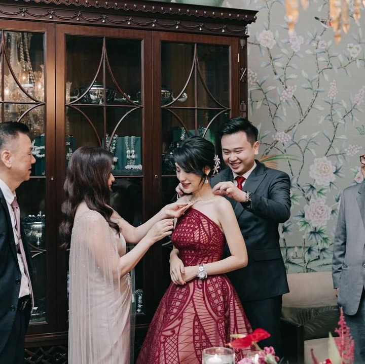<p>Dalam satu momen romantis, Michael terlihat sedang mengenakan kalung di leher Risa. Kedua orang tua mereka menyaksikkan momen ini dengan penuh kebahagiaan. (Foto: Instagram @santosorisa)</p>