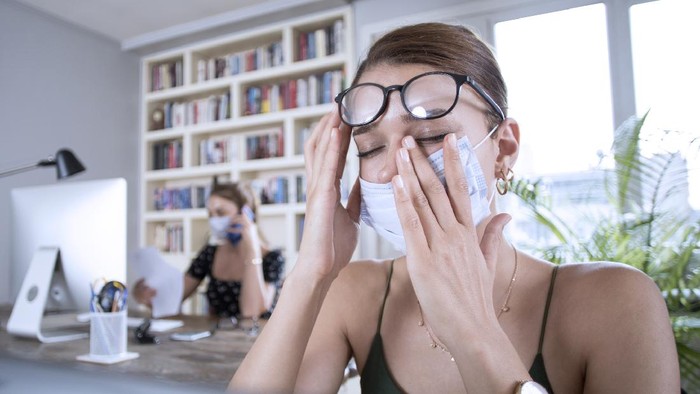 two woman working with protective face mask at office
