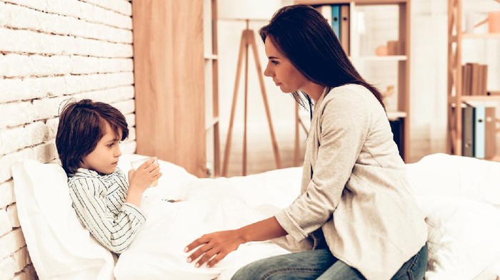 Mother Giving Medicine to Sick Son Lying Bed. Caring Mom Giving Sick Boy Pills. Worried Mother Giving Glass of Water to Ill Kid. Hospital Concept. Healthy Concept. Parent Concept.
