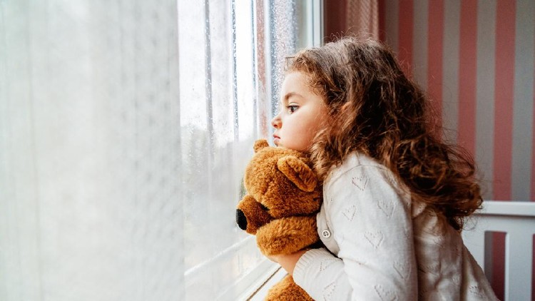 Little cute girl is watching from window to the rain with sadness get bored. . High quality photo
