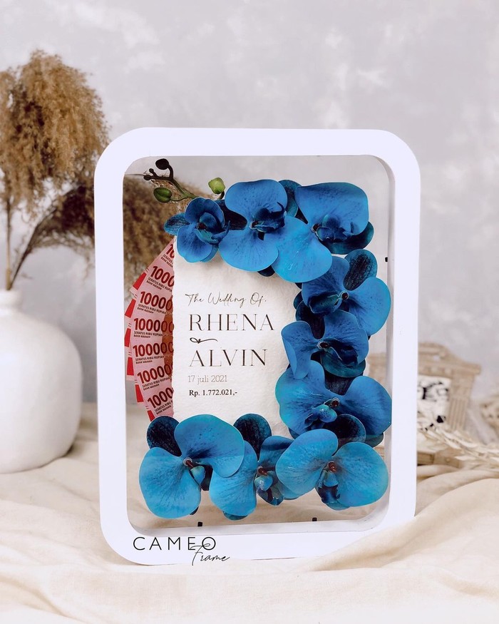 Mahar dengan hiasan bunga anggrek dapat dipilih kamu yang ingin mahar terlihat lebih elegan. Jenis mahar ini sangat cantik terlihat dengan replika uang tunai (foto: mahar uang tunai dengan anggrek / sumber: instagram.com/cameoframe.bdg)