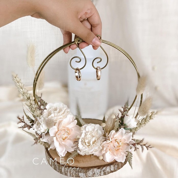 Bosan dengan ring box yang standar? kamu bisa mengadaptasikan seperti ini. Cincin yang tergantung menambah konsep unik dan lain dari biasanya. Setelah itu, tempatnya juga bisa menjadi pajangan (foto: cincin gantung / sumber: instagram.com/cameoframe.bdg)