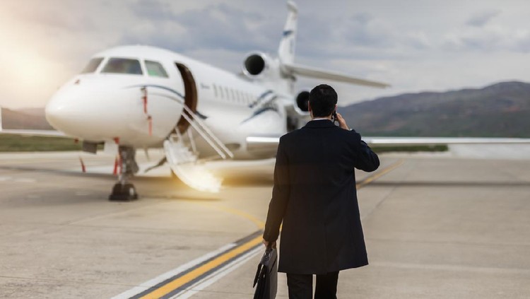 Rear View Of Businessman Walking Towards private airplane