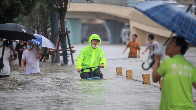 Setidaknya 12 orang tewas dan nyaris 200 ribu penduduk dievakuasi karena banjir akibat hujan yang disebut-sebut terlebat di China dalam 1.000 tahun belakangan.