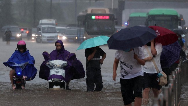 FOTO: Perjuangan Warga China Terjang Banjir Bandang