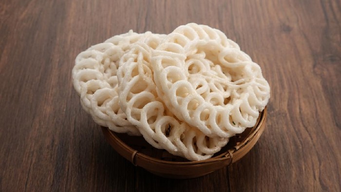 Krupuk or Kerupuk, Indonesia traditional crackers, served in bamboo plate on wooden table.