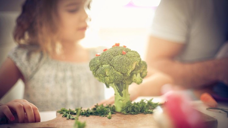 Ilustrasi anak makan brokoli Little creativity girl in kitchen with vegetable. Space for copy. Focus is on vegetable.