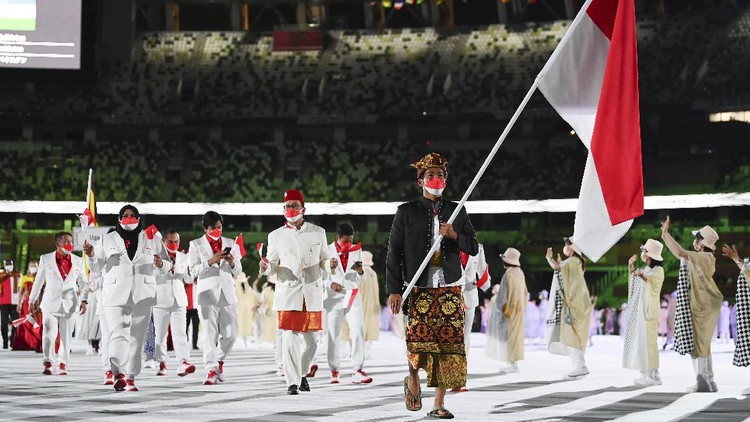 TOKYO, JAPAN - JULY 23: Flag bearer Nurul Akmal of Team Indonesia leads his team out during the Opening Ceremony of the Tokyo 2020 Olympic Games at Olympic Stadium on July 23, 2021 in Tokyo, Japan. (Photo by Matthias Hangst/Getty Images)