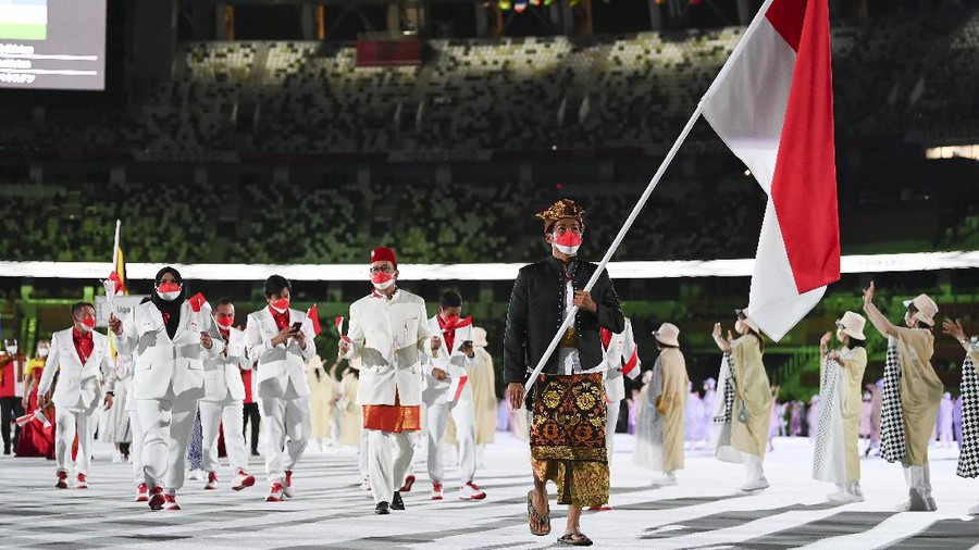 TOKYO, JAPAN - JULY 23: Flag bearer Nurul Akmal of Team Indonesia leads his team out during the Opening Ceremony of the Tokyo 2020 Olympic Games at Olympic Stadium on July 23, 2021 in Tokyo, Japan. (Photo by Matthias Hangst/Getty Images)