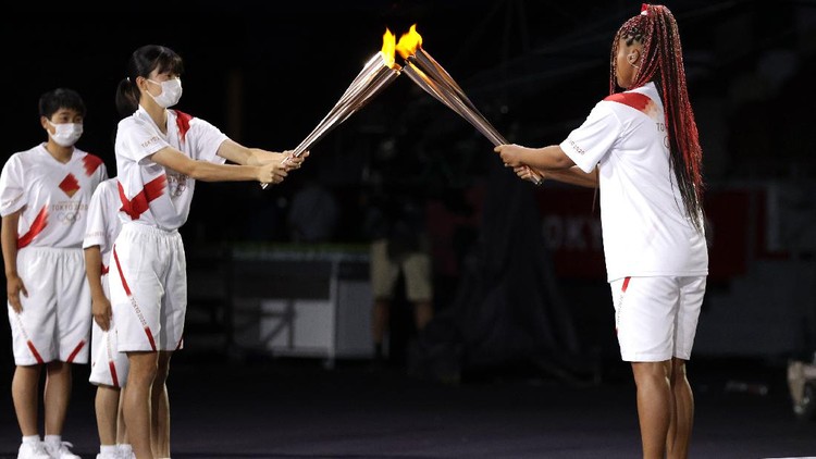 Olimpiade Tokyo 2020 TOKYO, JAPAN - JULY 23: Naomi Osaka of Team Japan is handed the Olympic Torch during the Opening Ceremony of the Tokyo 2020 Olympic Games at Olympic Stadium on July 23, 2021 in Tokyo, Japan. (Photo by Hannah McKay - Pool/Getty Images)