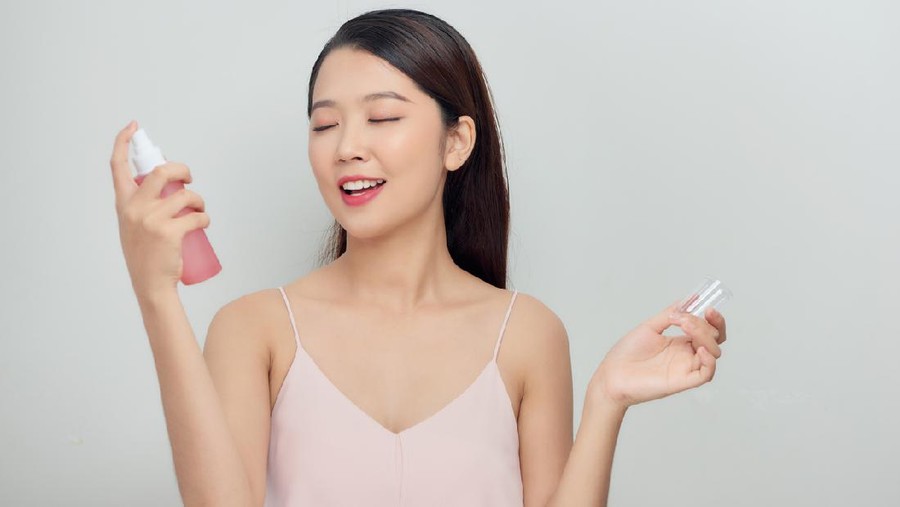Beautiful woman face spray on face lotion cosmetology on white background isolation