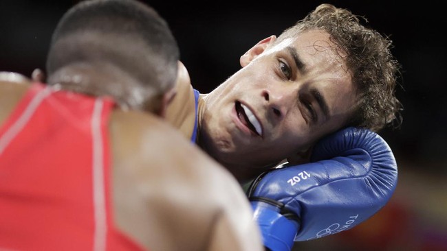 Petinju Maroko Youness Baalla mencoba menggigit petinju Selandia Baru David Nyika dalam pertarungan tinju kelas berat di Olimpiade Tokyo 2020.