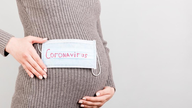 hamil Worried pregnant woman with protective face mask on sofa at home. sick pregnant woman during COVID-19.