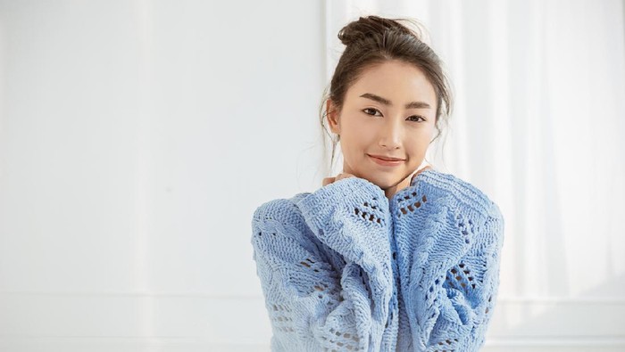 Portrait of young beautiful asian woman relax face in winter bedroom. Closeup sexy beauty fashion girl healthy makeup facial treatment perfect glow skin. Smile happy asia korean girl feel cold.
