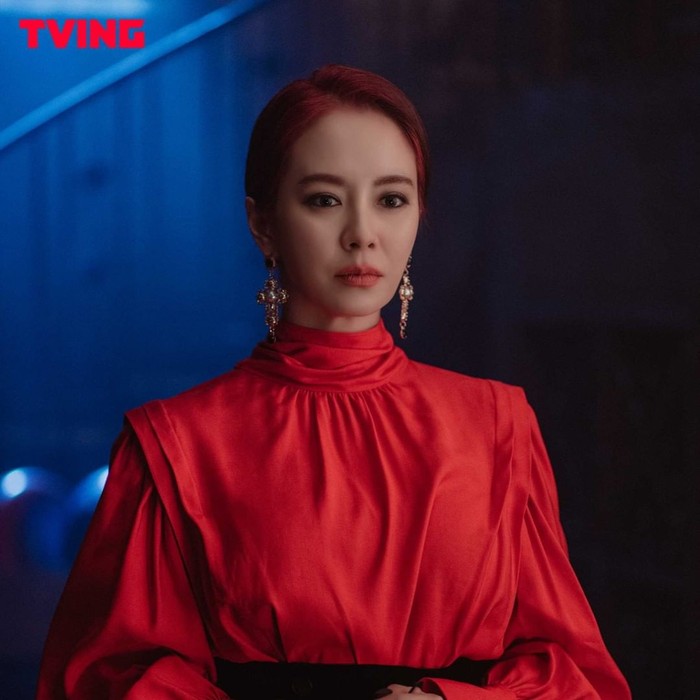 Nggak cuma warna hitam, Song Ji Hyo juga tampil badass dengan gaun berwarna merah senada dengan rambutnya. Anting panjang yang dipakainya tampak mewah dan stand out. /Foto: instagram.com/tving.official